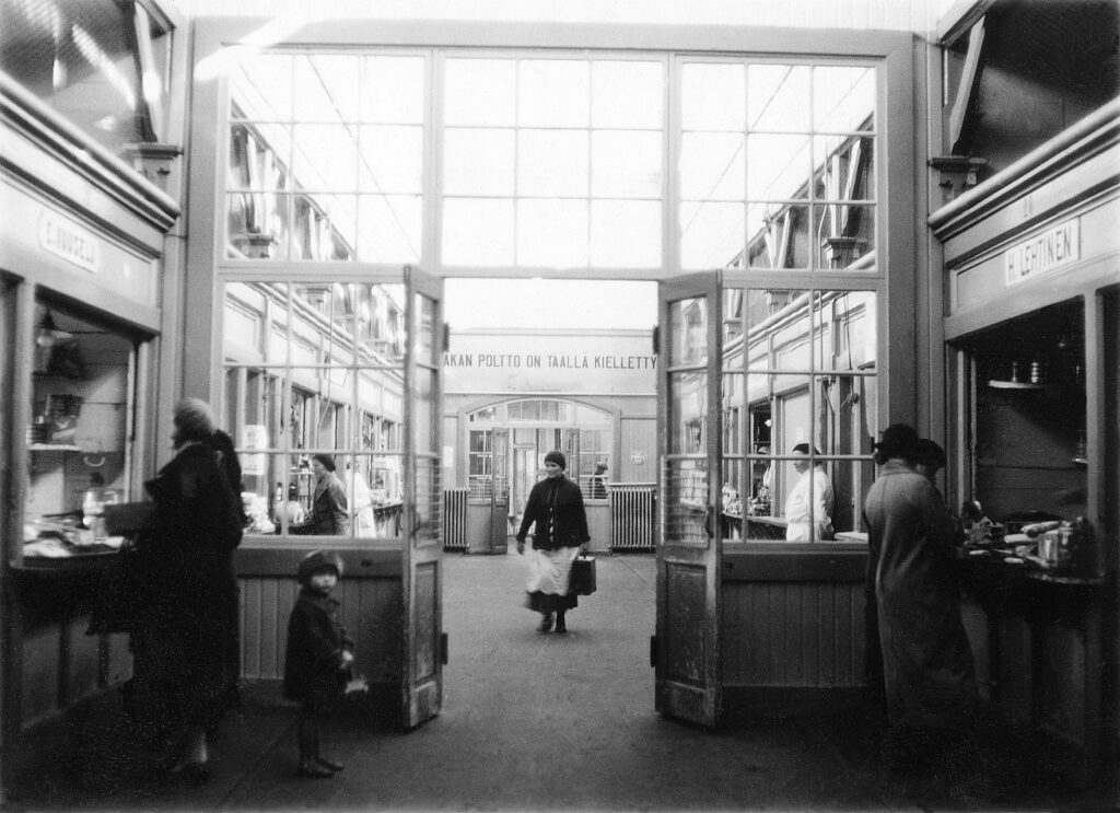 Mustavalkoinen sisäkuva kotkan tiilirakenteisesta kauppahallista.